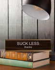 Suck Less Nameplate